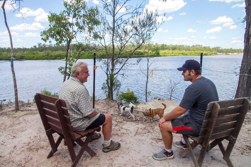 Two men and their dogs sit overlooking the Gregory River