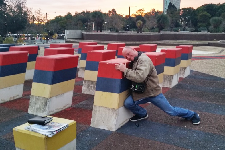 Eddie Bannon tries to souvenir himself a part of the plaza sculpture