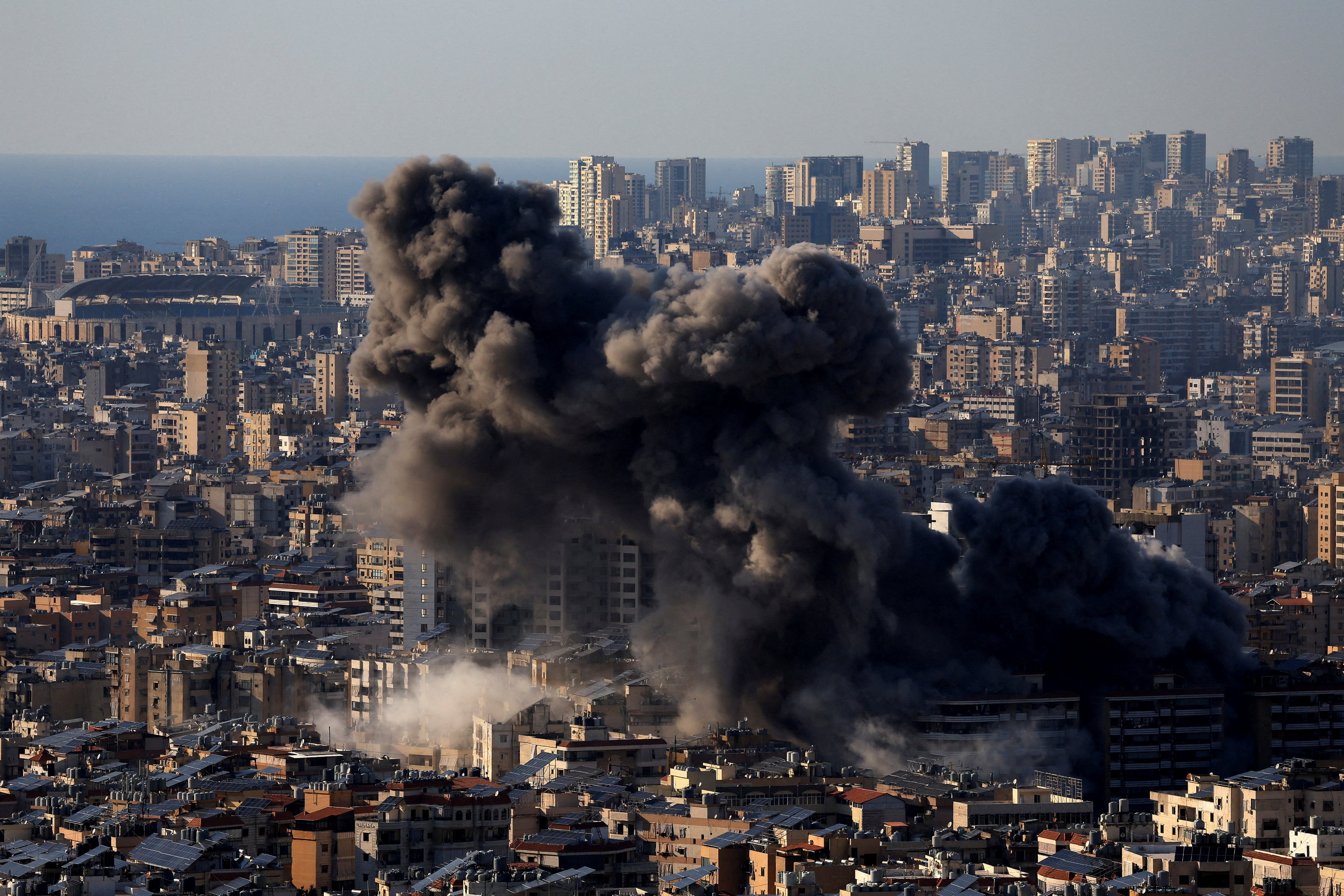 Smoke rises from a densely built up area of suburban Beirut.