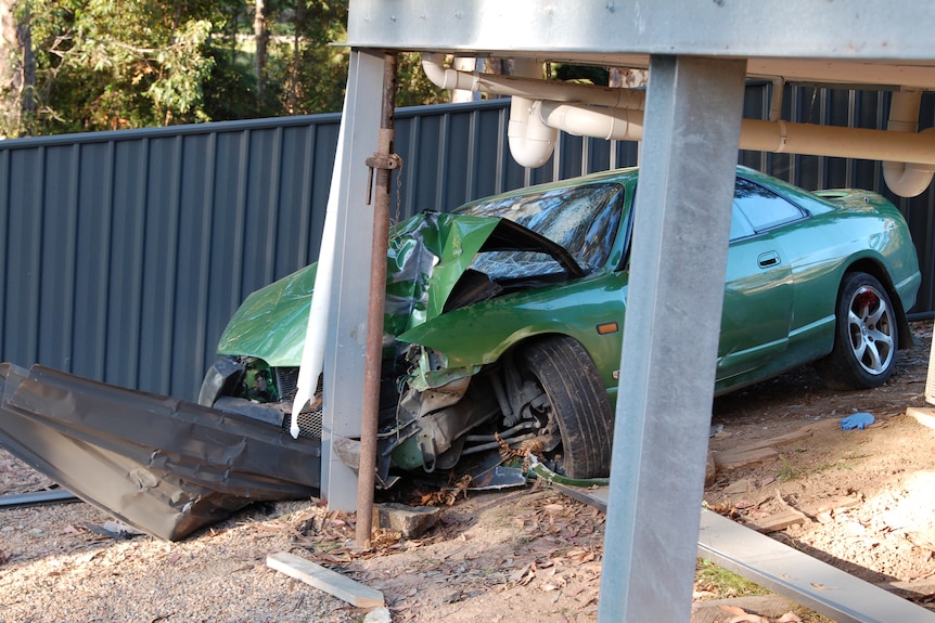 A green car damaged by a crash.