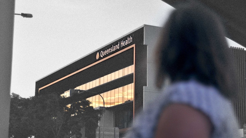 A woman stands looking at a Queensland Health building. Her face can't be seen. The photo is partly black and white.