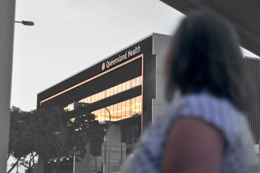A woman stands looking at a Queensland Health building. Her face can't be seen. The photo is partly black and white.