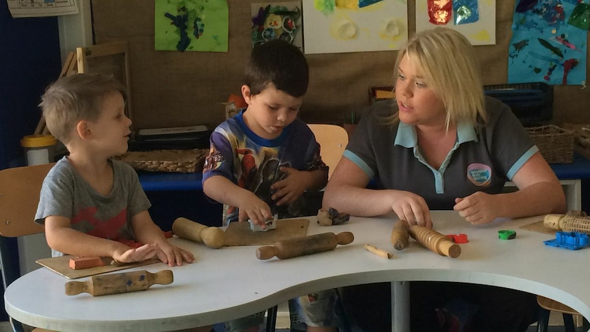 An early learning educator rolls shapes with two boys at a Goodstart Early Learning centre in Darwin.
