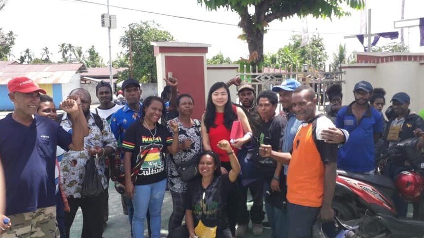 Ms Koman stands with a group of Papuan activists.