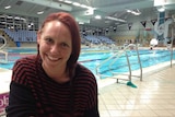 Sally Thompson from the Hobart migrant resource centre sitting by a pool