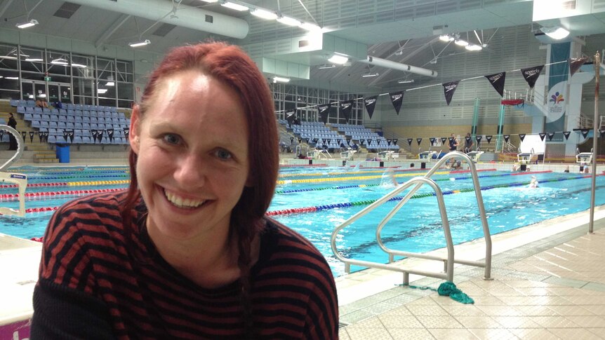 Sally Thompson from the Hobart migrant resource centre sitting by a pool