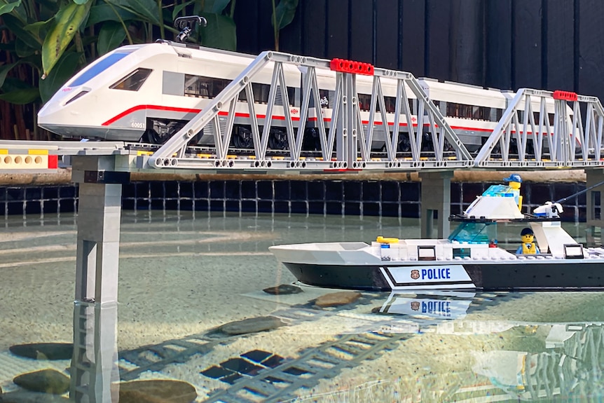 Lego train runs across bridge built in pool