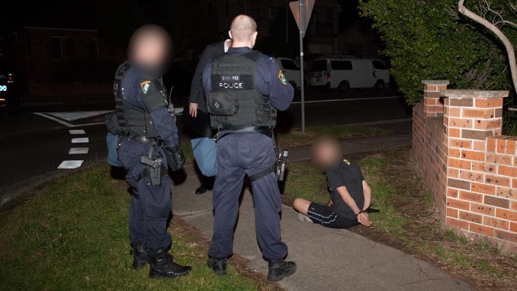 Man cuffed outside house in sydney anti-terrorism raids