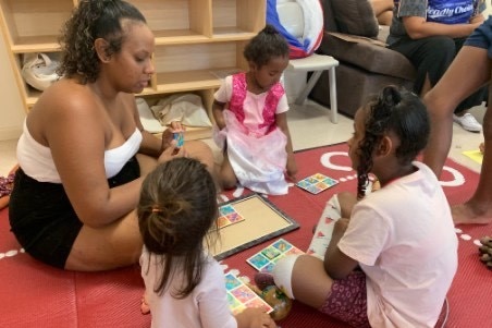 Mackapilly Sebasio sitting with children at the Birthing in Our Community service in Salisbury, Brisbane. 