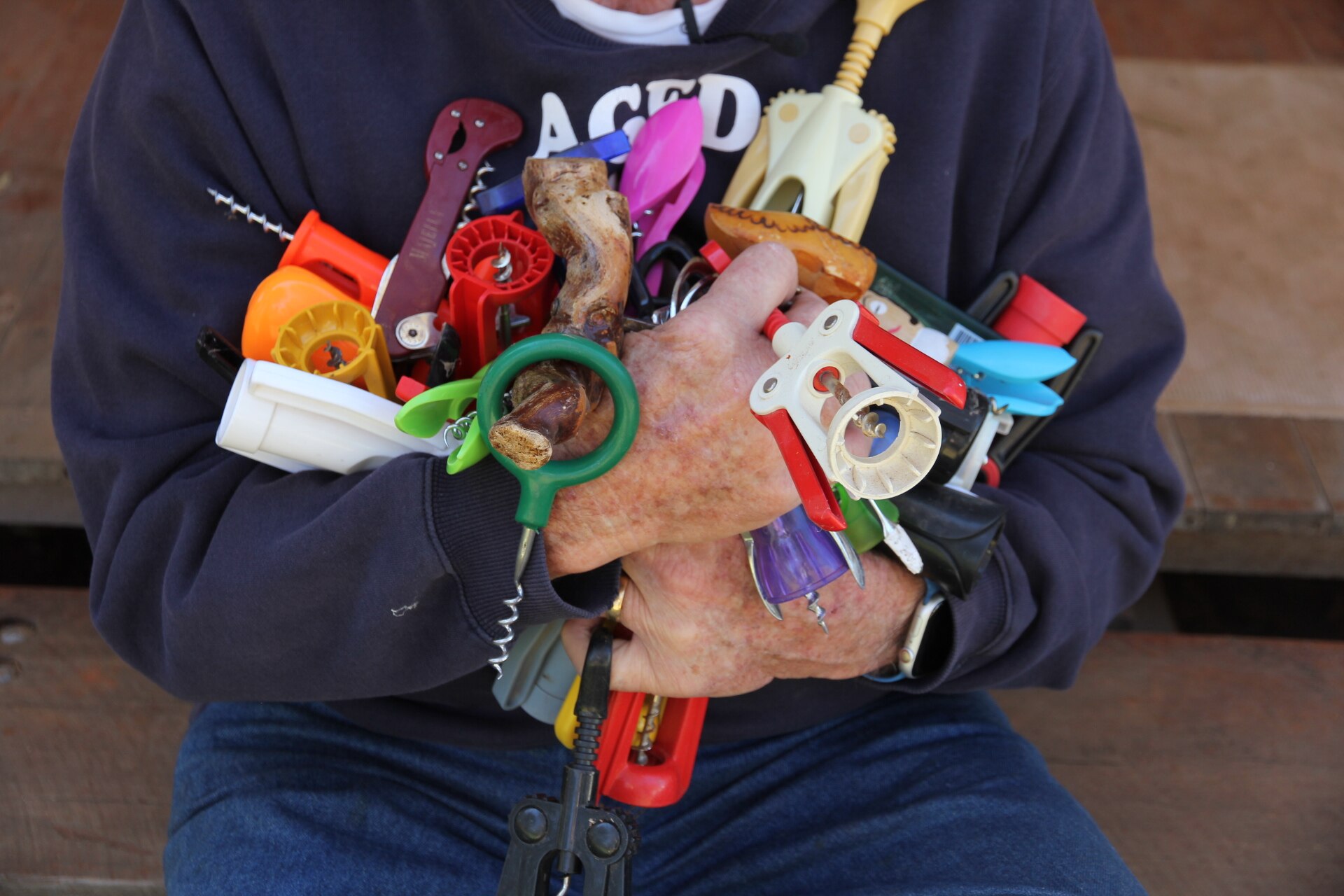 A person holds a jumble of plastic corkscrews.