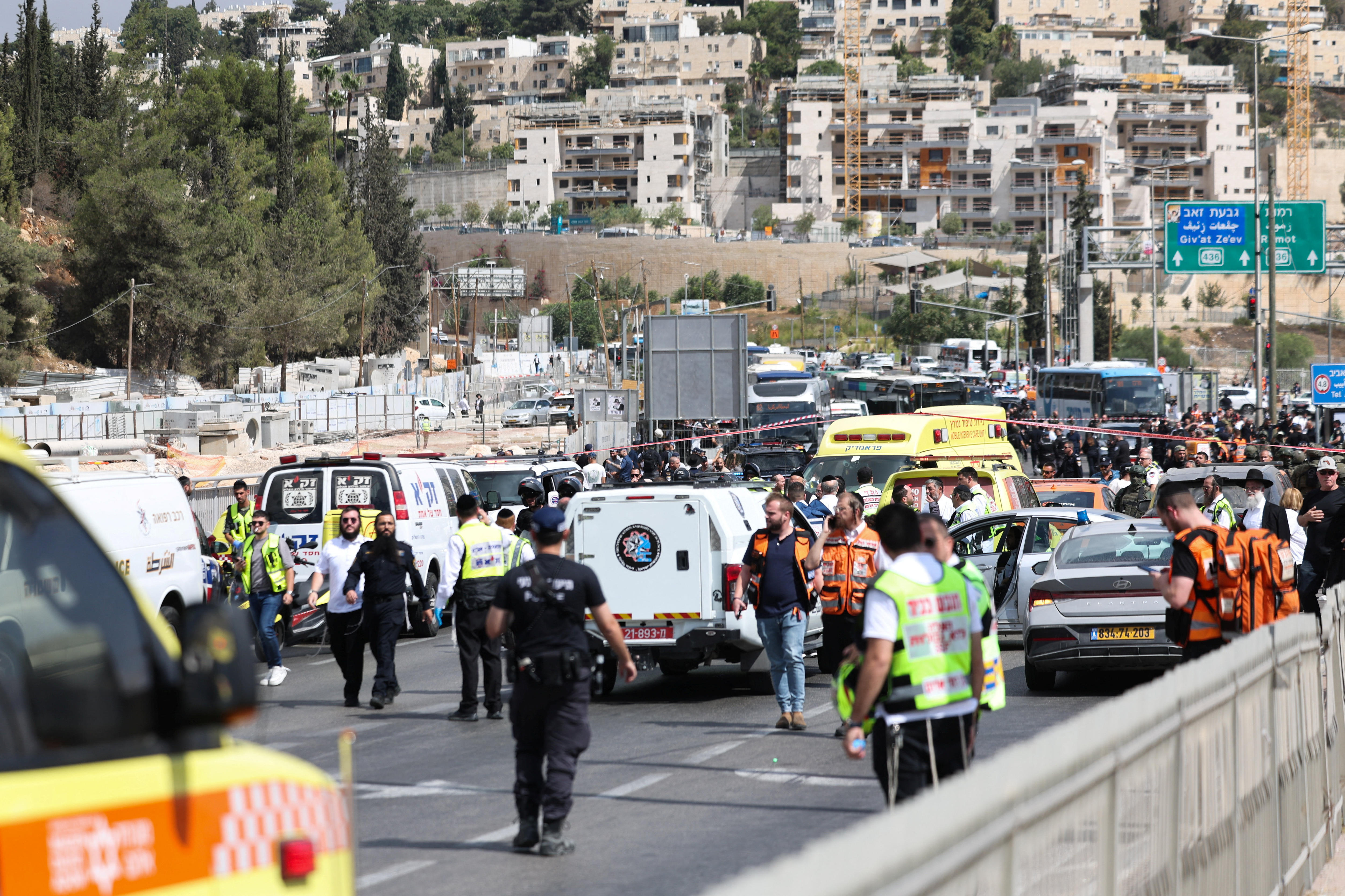 A crowd of emergency services vehicles and workers at a scene