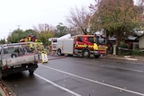 Fire fighting vehicles sit on a street at Ferryden Park in front of a home that was damaged in a fire