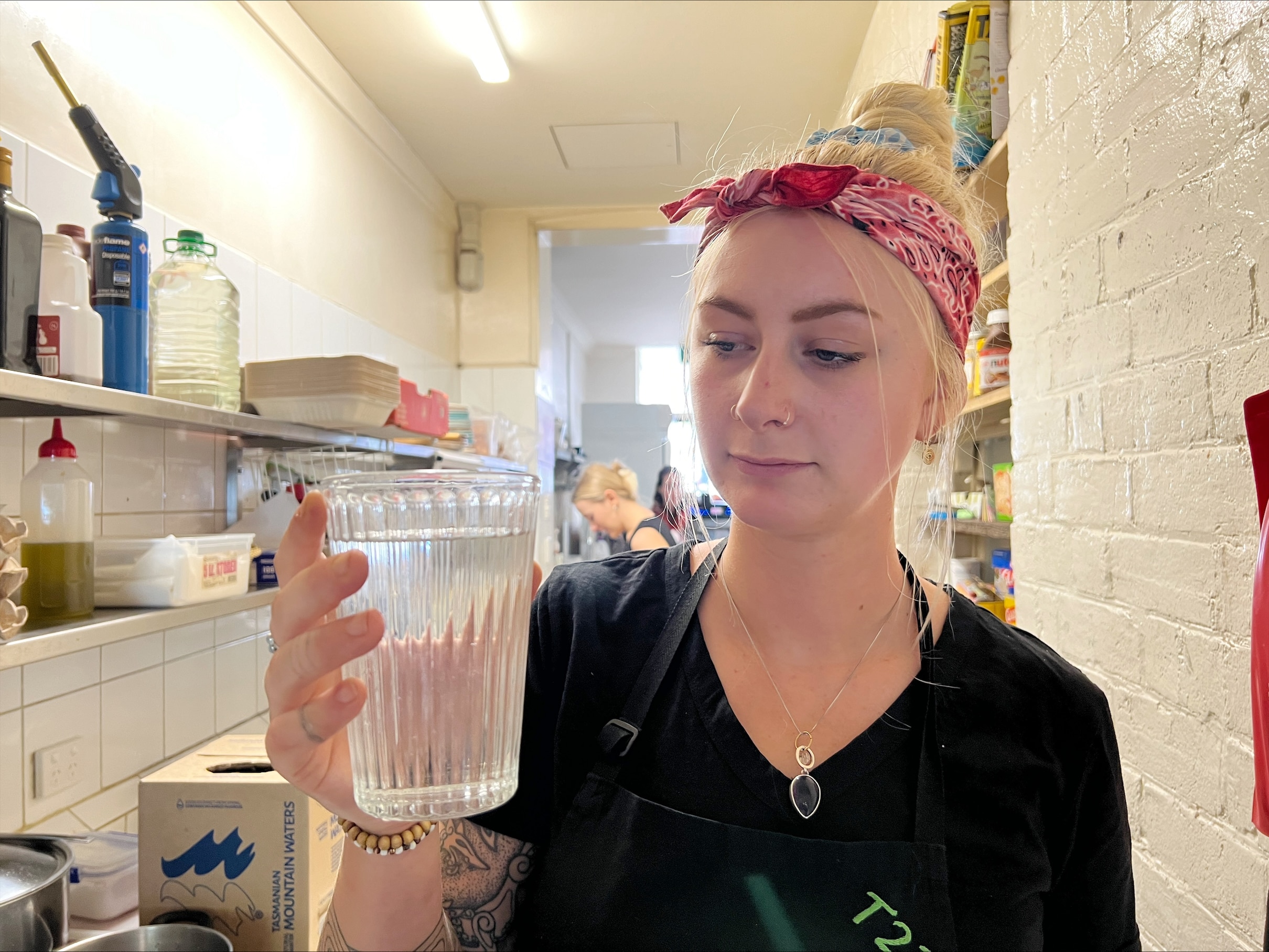 A woman holds a glass of water