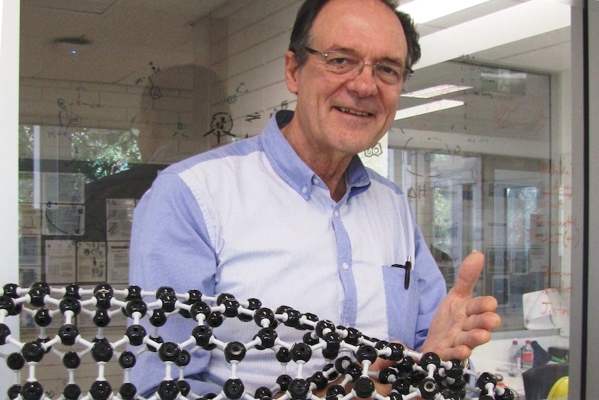 Professor Colin Raston holds a plastic model of carbon nanotubes.