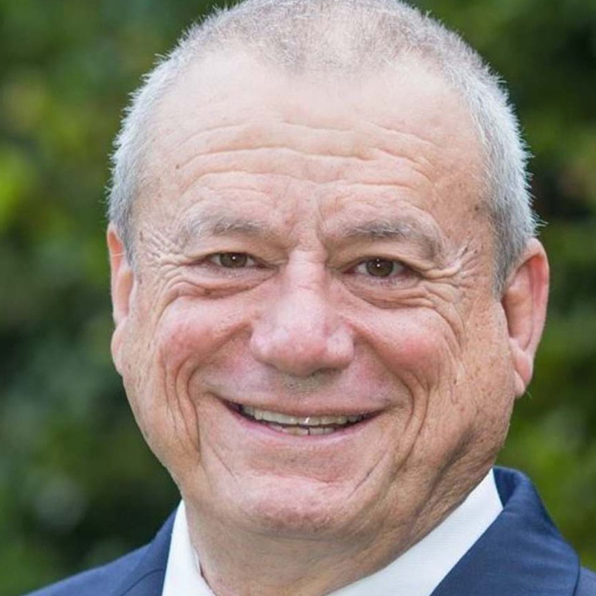 Close-up of Peter Russo with short-cropped hair smiling at the camera