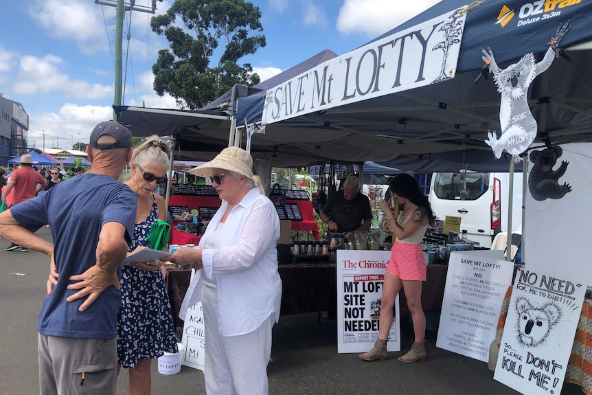 Woman signing a petition at a 'Save Mt Lofty' stall set up at the local markets.