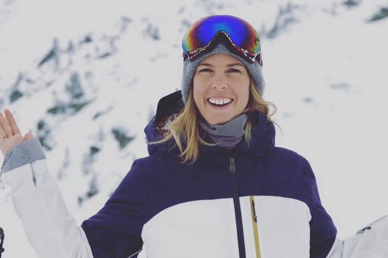 Torah Bright smiles at camera with mountains in background.