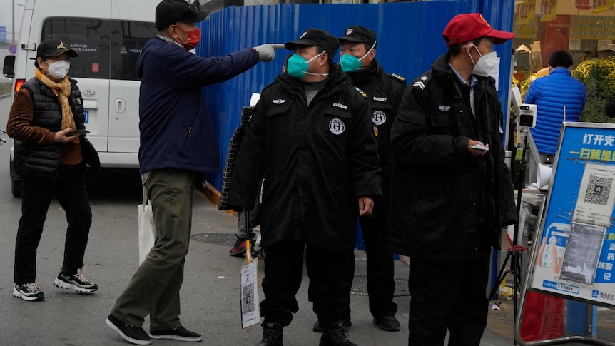 Security guards control access into a community under lockdown in Beijing.