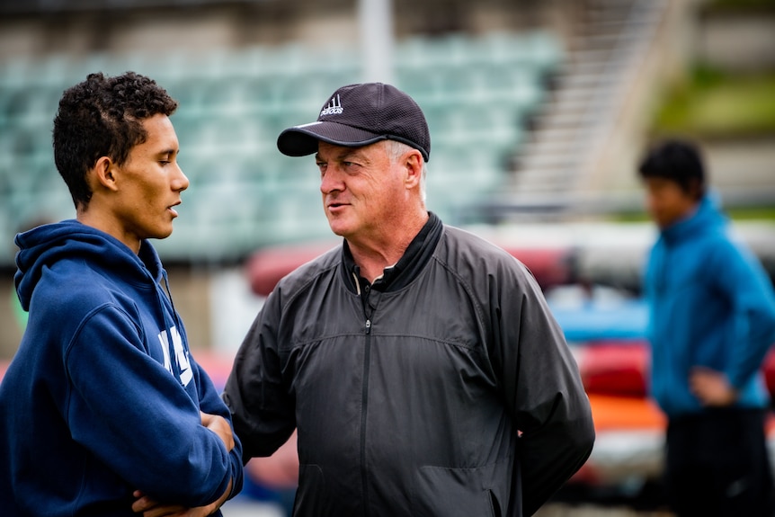 John Quinn talks to an athlete.