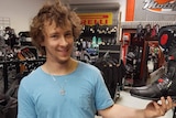 Dann Jenkins holds a shoe in a bike shop