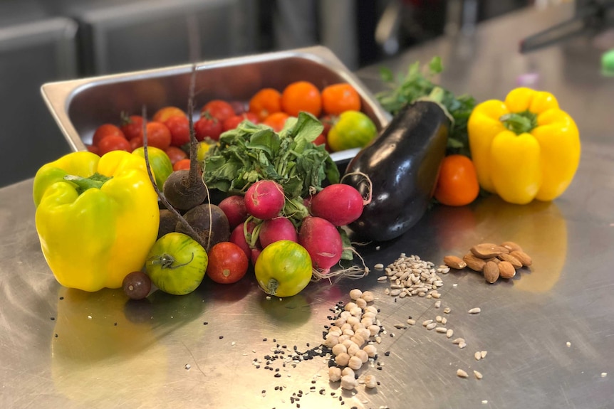 A pile of vegetables on a metal table.