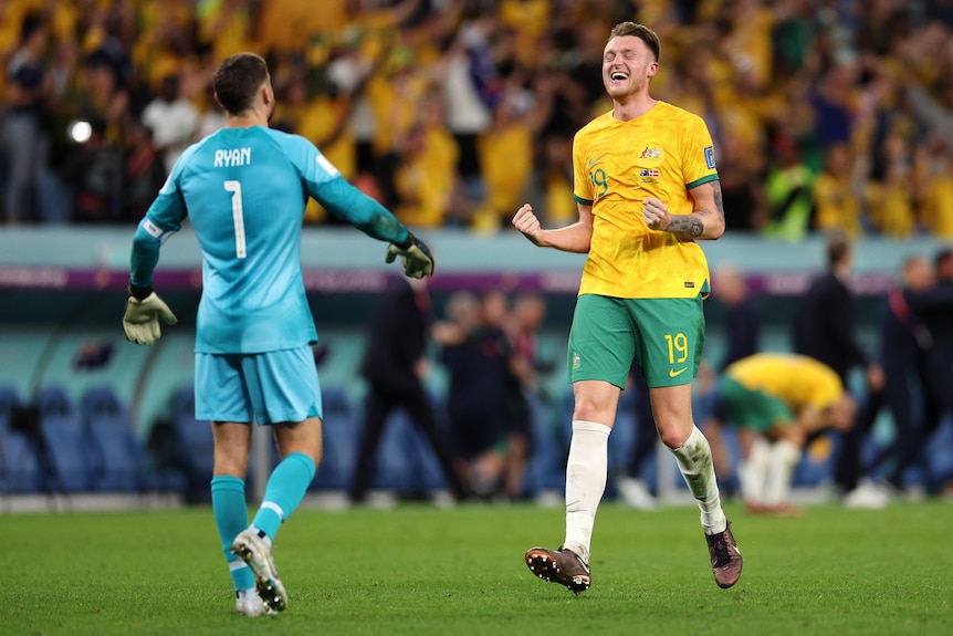 Socceroos defender Harry Souttar closes his eyes and smiles in celebration as he runs to hug goalkeeper Mat Ryan after a game.