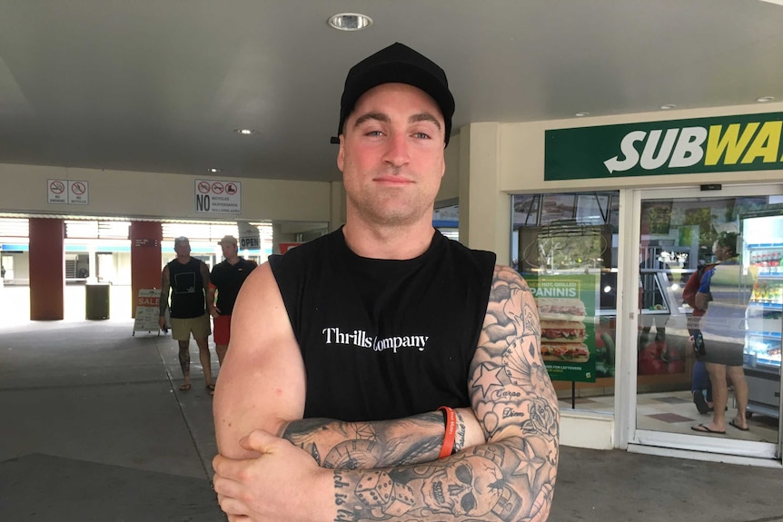 Miner Troy Rogers stands in front of a fast food outlet.