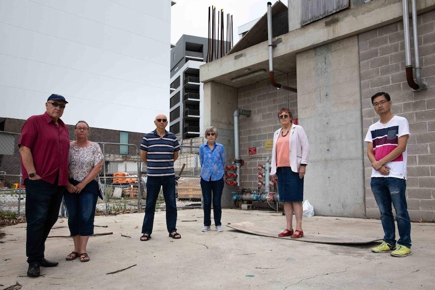 Six people stand on a roof