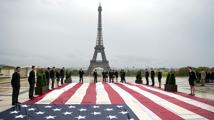 Student officers in Paris stand next to a giant US flag during a 9/11 memorial