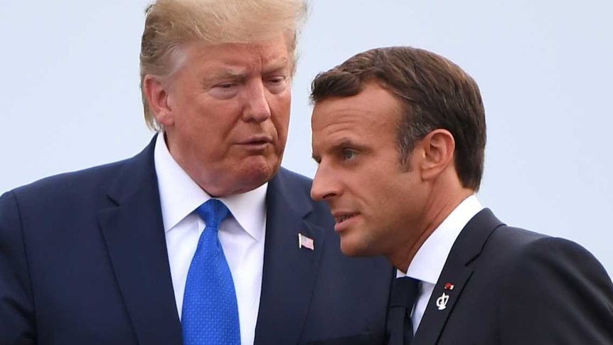 Donald Trump talks to Emmanuel Macron as Brigitte and Melania hold hands