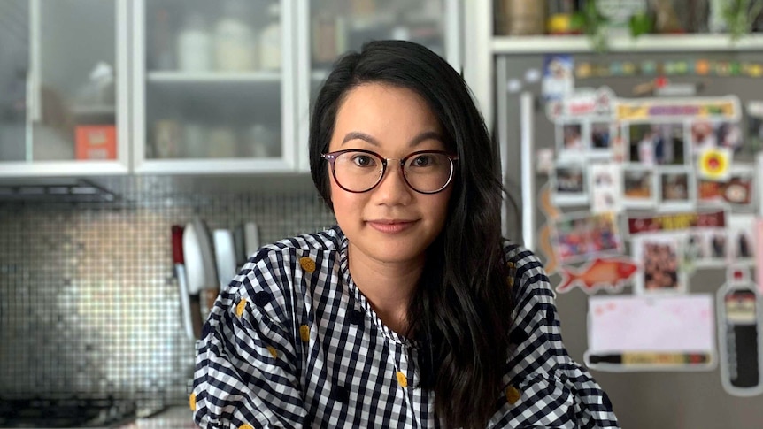 Food writer Diem Tran standing in her kitchen, sharing tips on how to save money cooking at home.