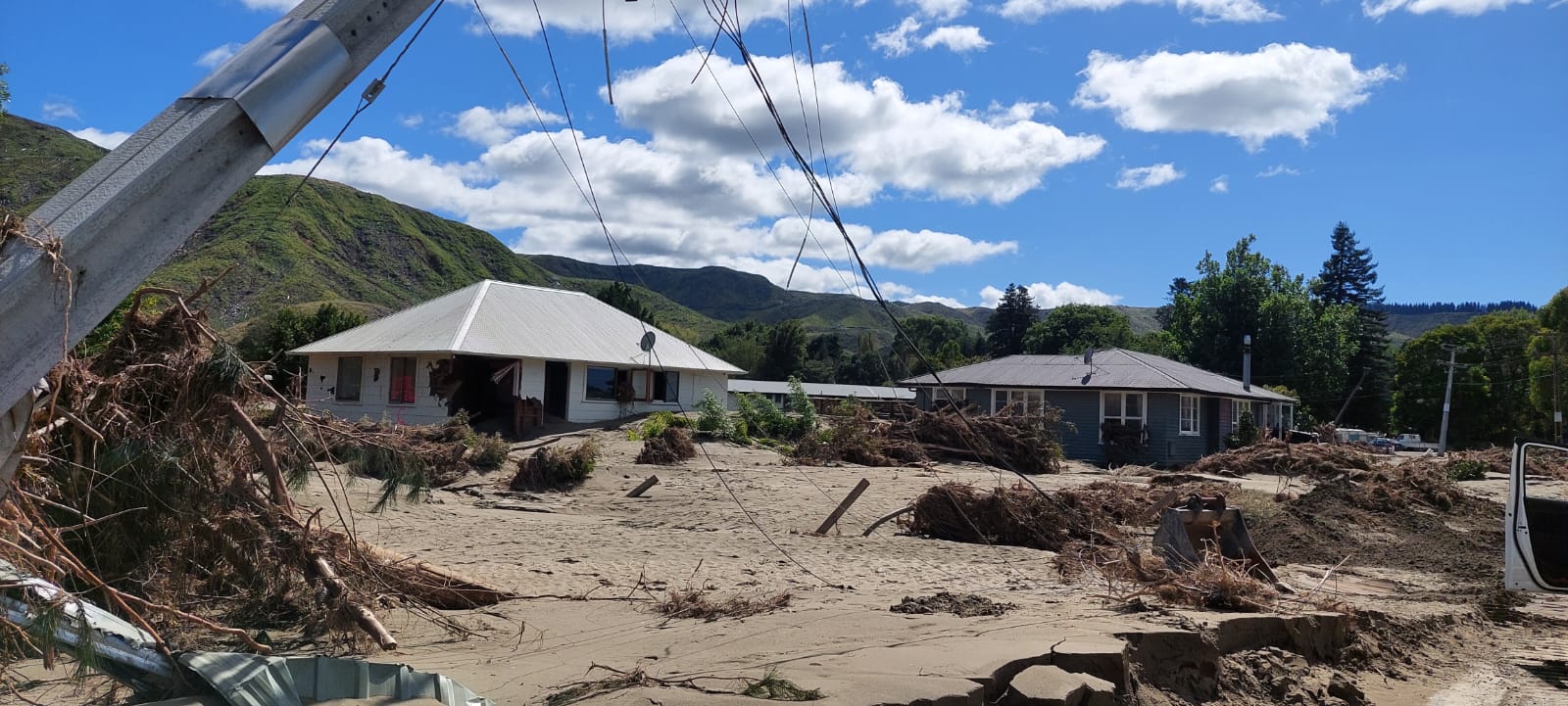 Power lines and houses surrounded by mud. 
