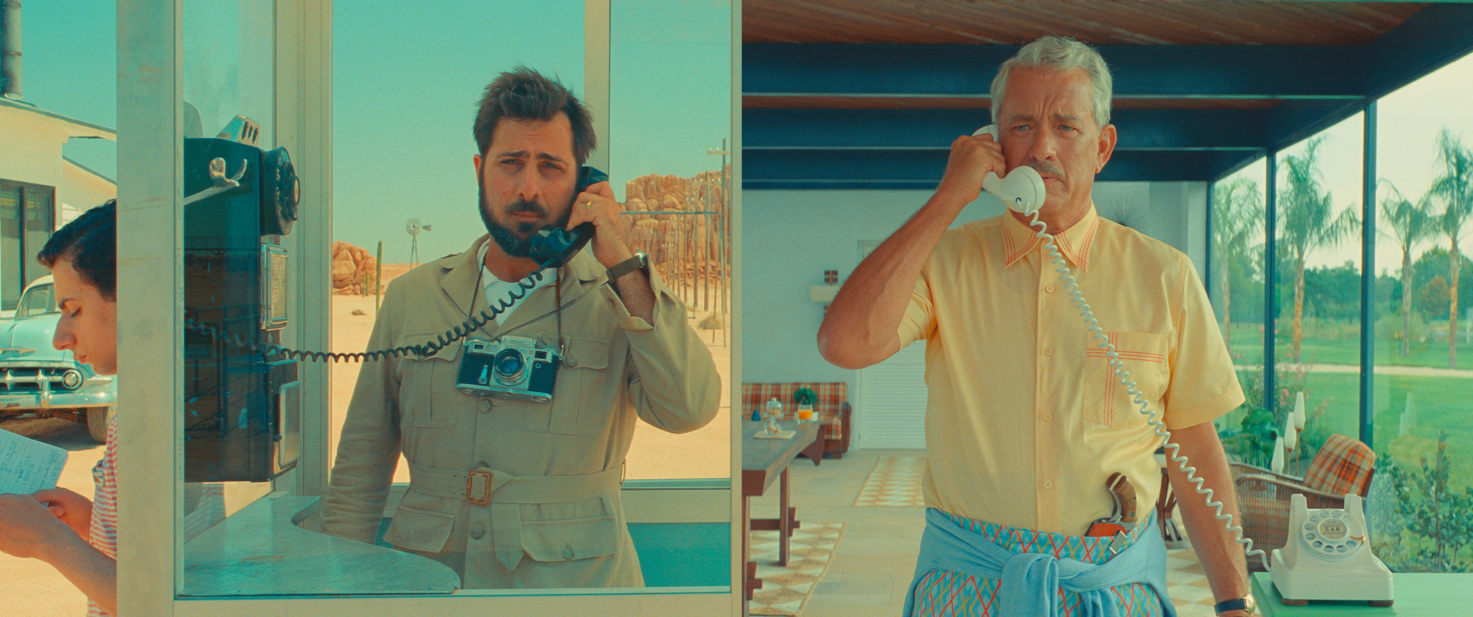 A split screen image of Jason Schwartzman, a brunette white man, and Tom Hanks, a grey-haired white man, talking on the phone.
