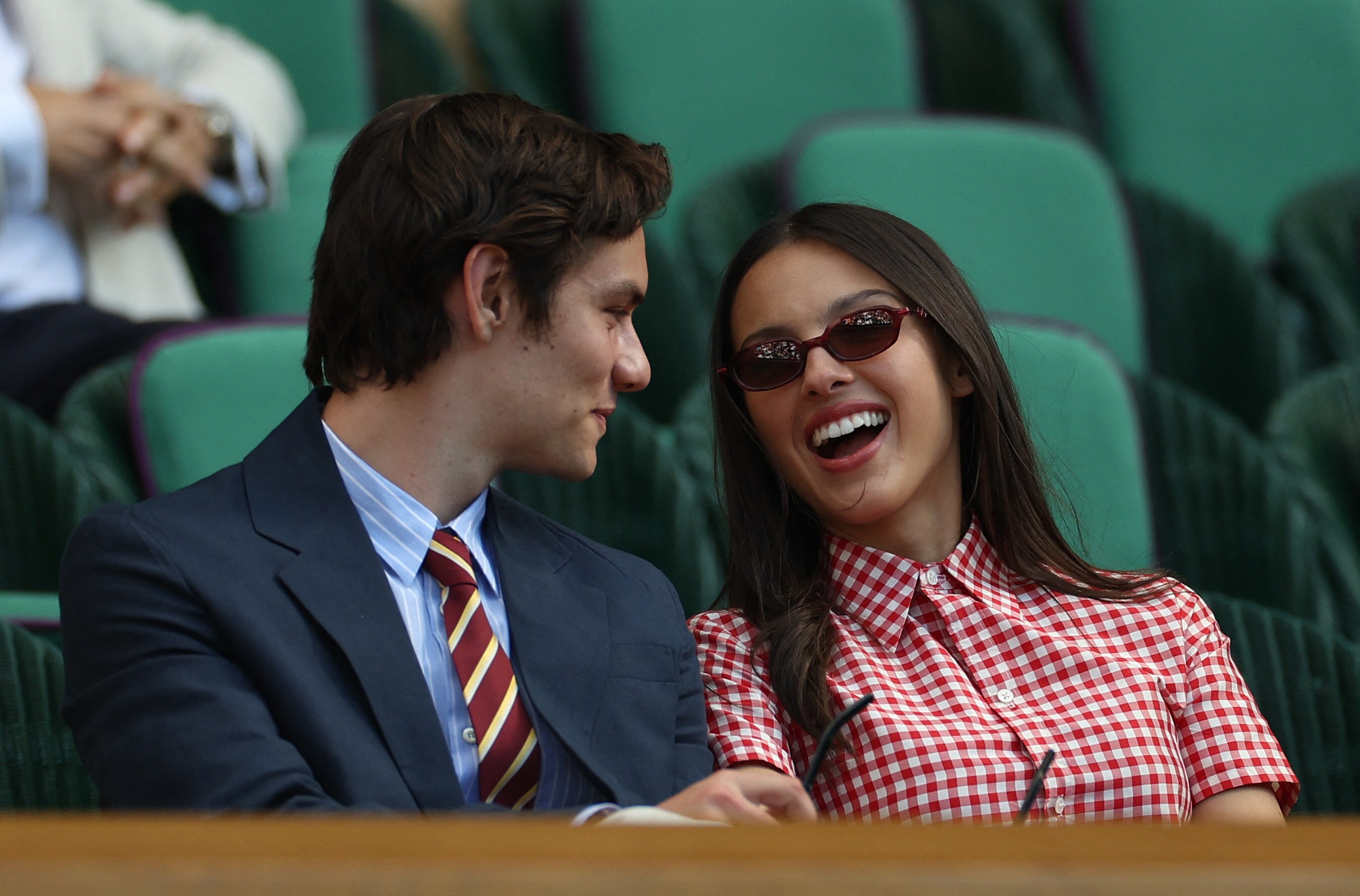 Olivia Rodrigo and Louis Partridge laugh and chat in the royal box
