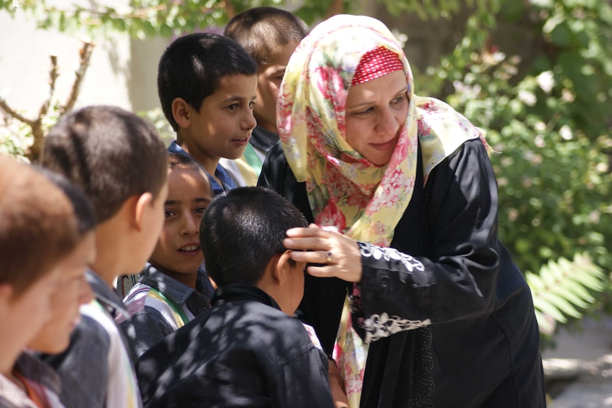 A women talks with a group of boys