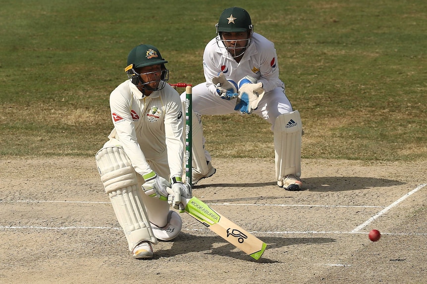 Telephoto shot of a cricketer finishing a reverse sweep shot.