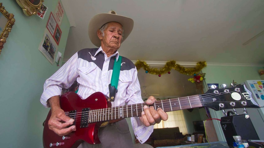 Musician Bill Lawton at home on his guitar