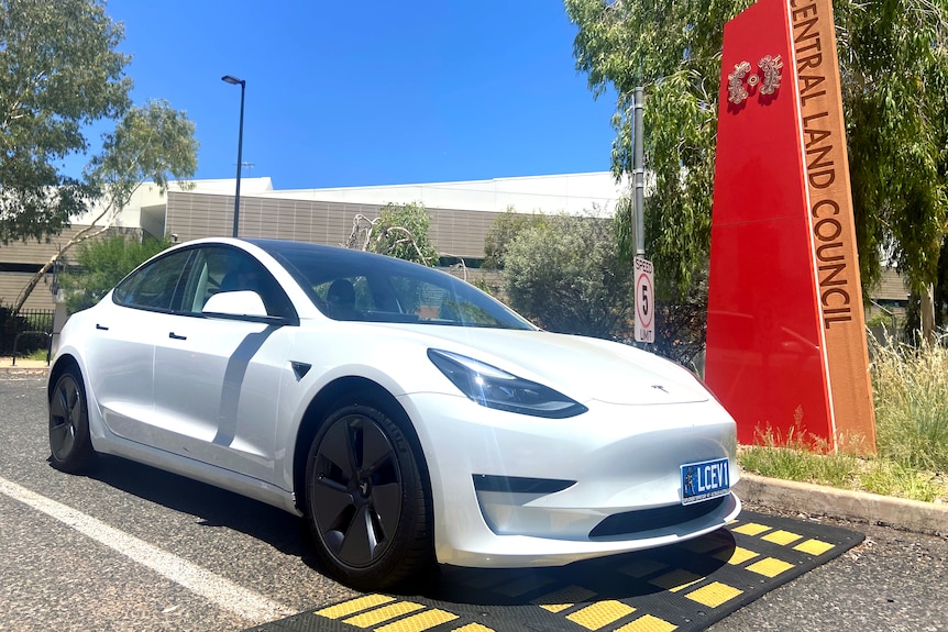 A white electric vehicle sits in the driveway of the Central Land Council.