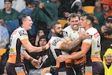 Corey Oates smiles and is hugged by three other players in white shirts