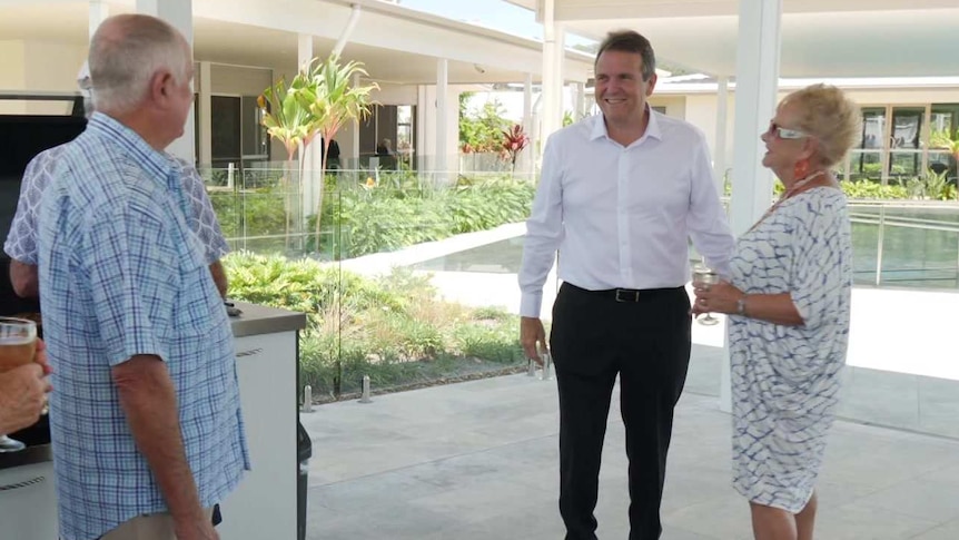 Bevan Geissmann mixes with residents of Halcyon Lakeside at a barbecue under a verandah.