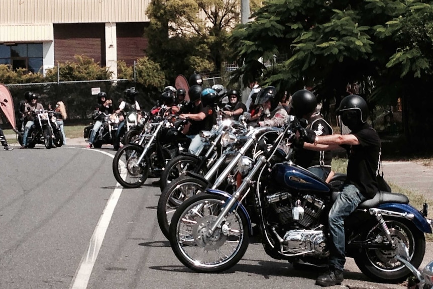 Dozens of motorcyle riders and bikes line the street ahead of a Hells Angels charity ride.