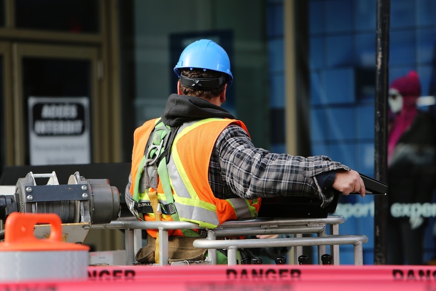 A construction worker in a hard hat on a building site.