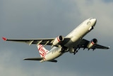 A Virgin plane flies nose upward after taking off.