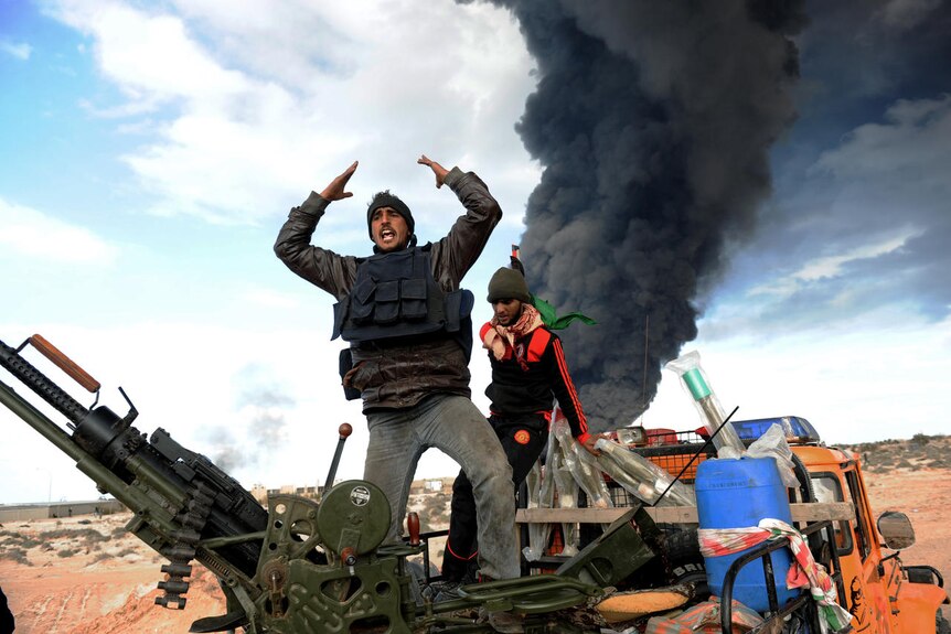 Libyan rebel fighters react during clashes with forces loyal to leader Moamar Gaddafi (AFP: Roberto Schmidt)