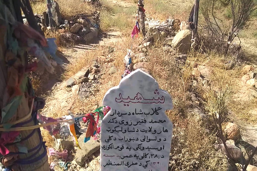 A grave site with a gravestone and colourful decorations.