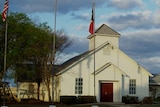 A small white church with American flags out the front.
