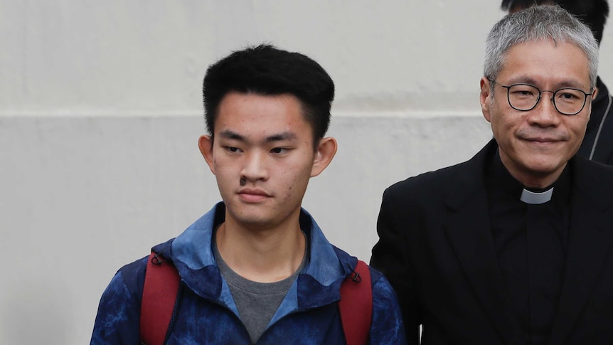 Murder suspect Chan Tong-kai walks out of prison, accompanied by a priest.