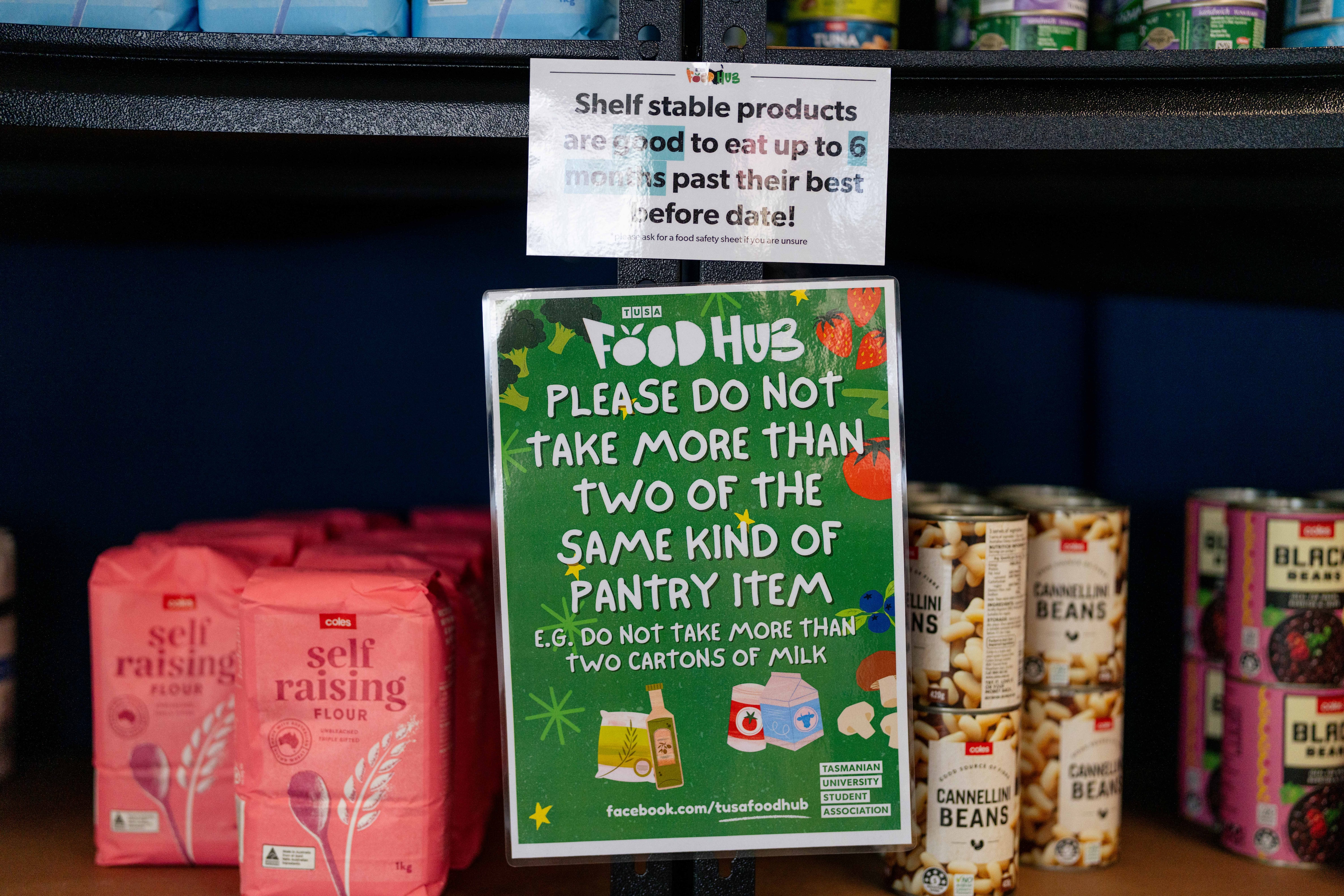 Flour, bean mix cans and signage on the shelf in a mini grocery store
