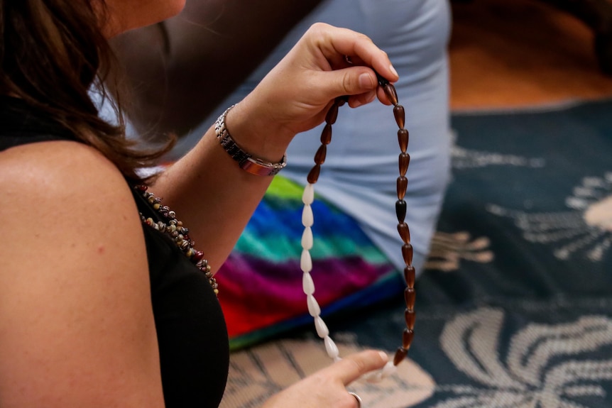 Dr Sarah Ireland runs her hands down a row of beads.