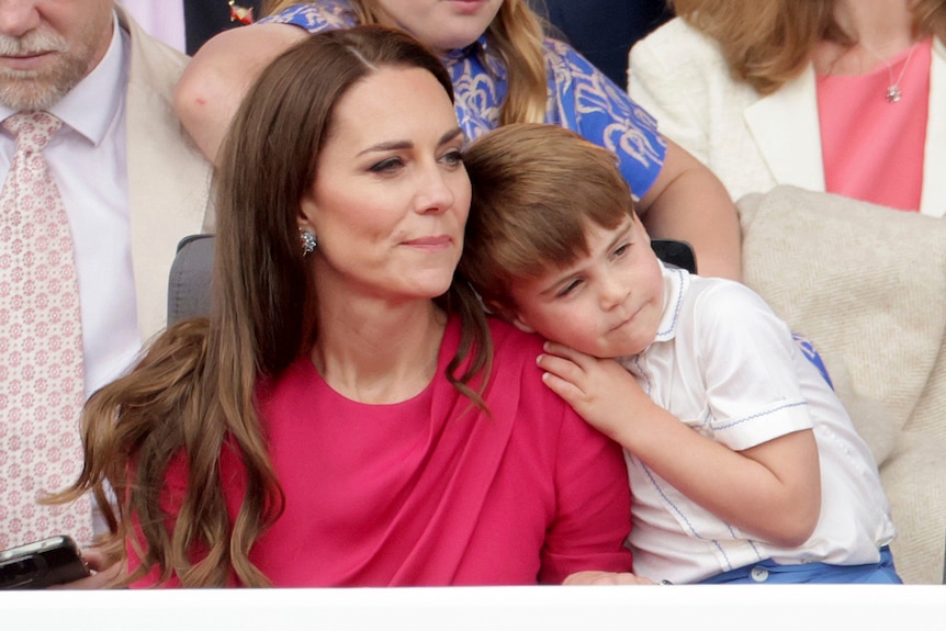 Louis leans on his mum Kate. 